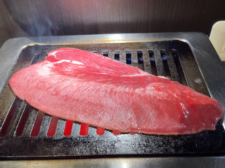 川口駅東口カウンター焼肉「肉松」の長い牛タンを焼く